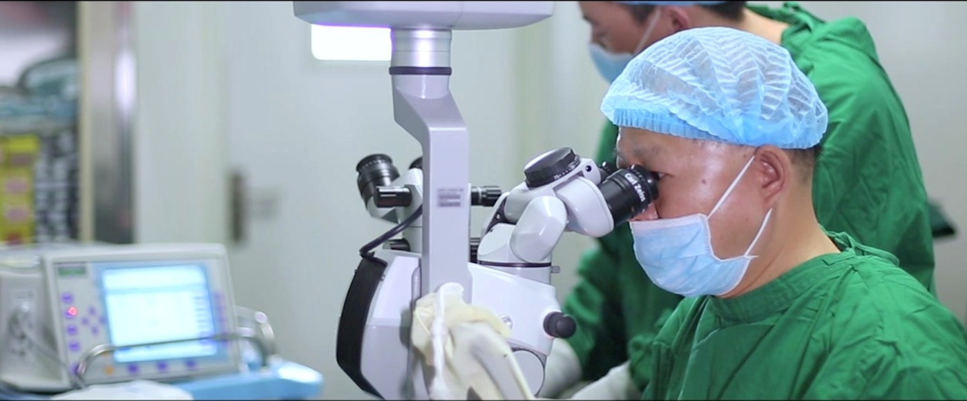 Ophthalmologist demonstrating cataract surgery through an operating microscope
