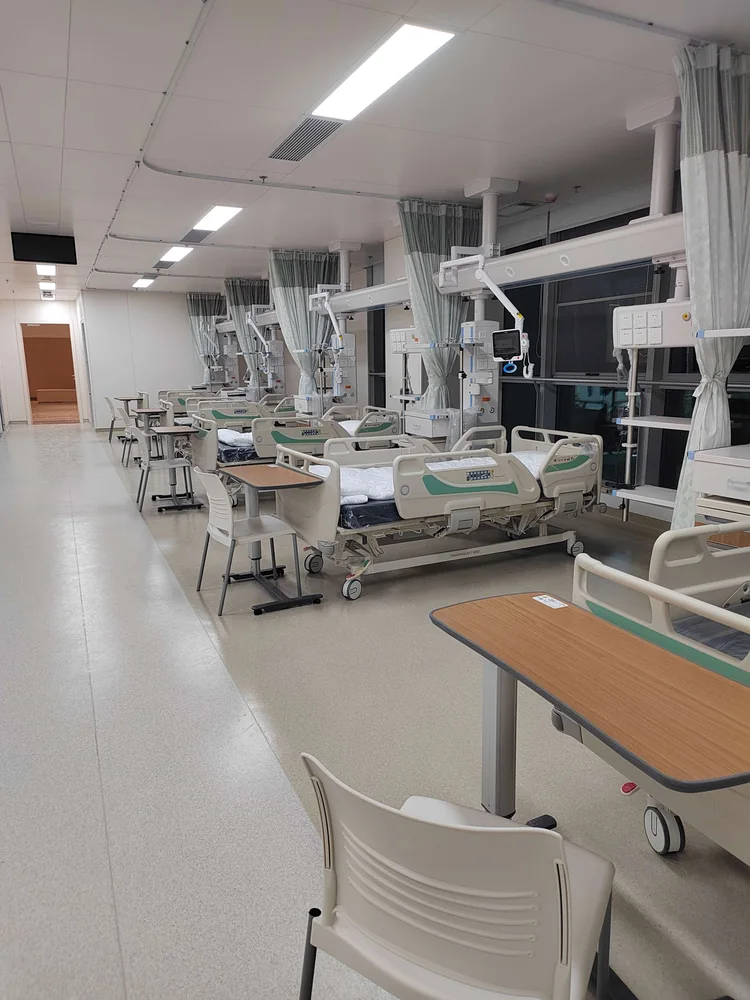 Bed spaces arranged with suspended equipment and bedside services.