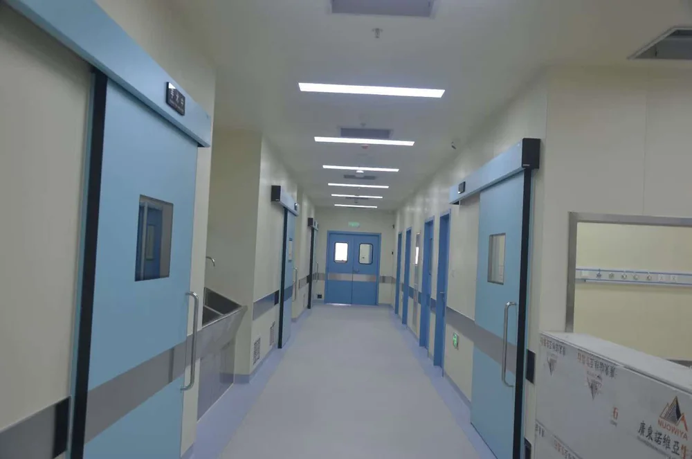 Medical corridor with sliding doors and integrated wall services.